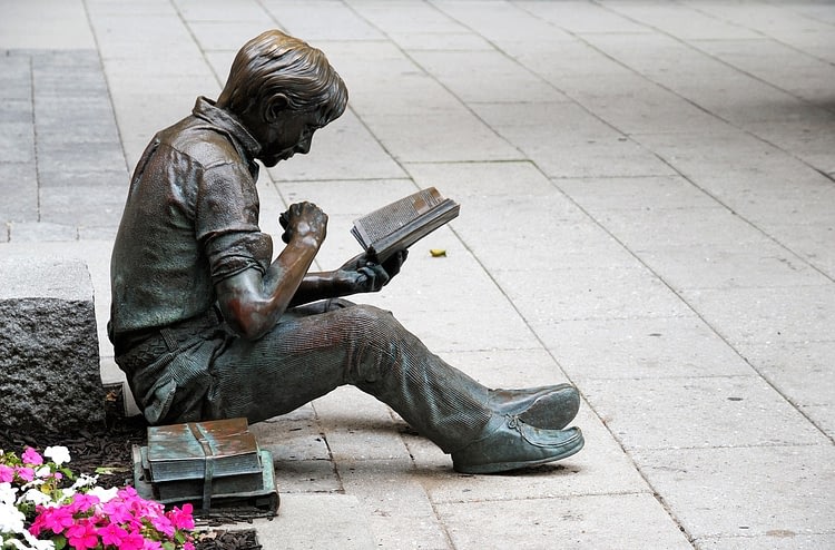 A statue of a studying student.